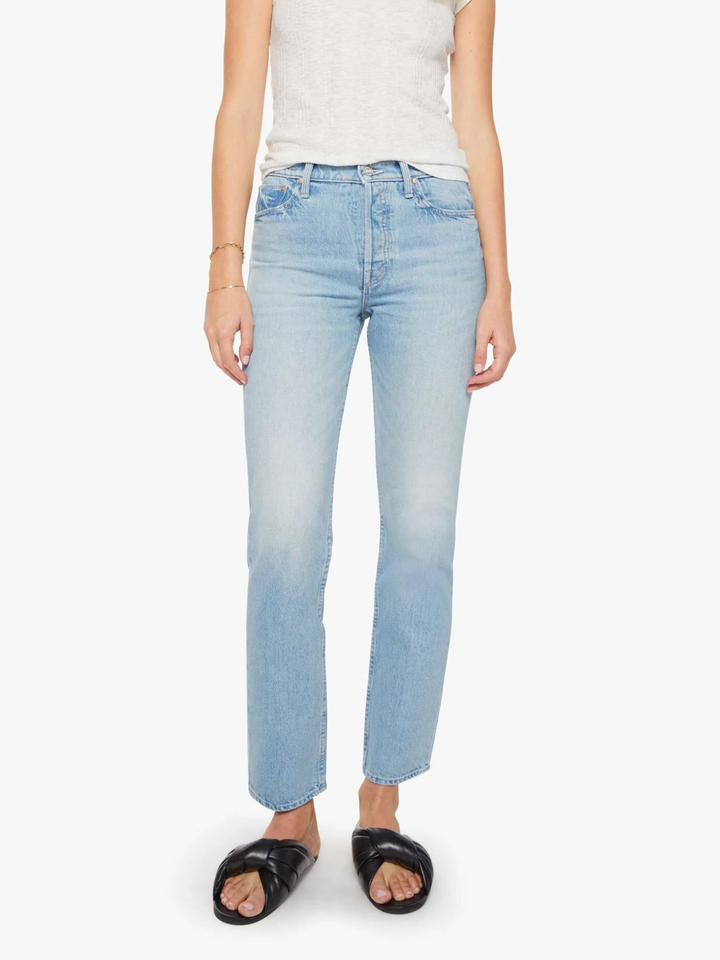 A model wearing light-wash blue straight-leg jeans, a light gray sleeveless top, and black slide sandals, shown from the waist down against a plain white background.
