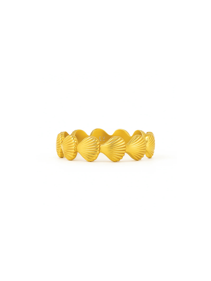 Gold ring with shell design on a white background