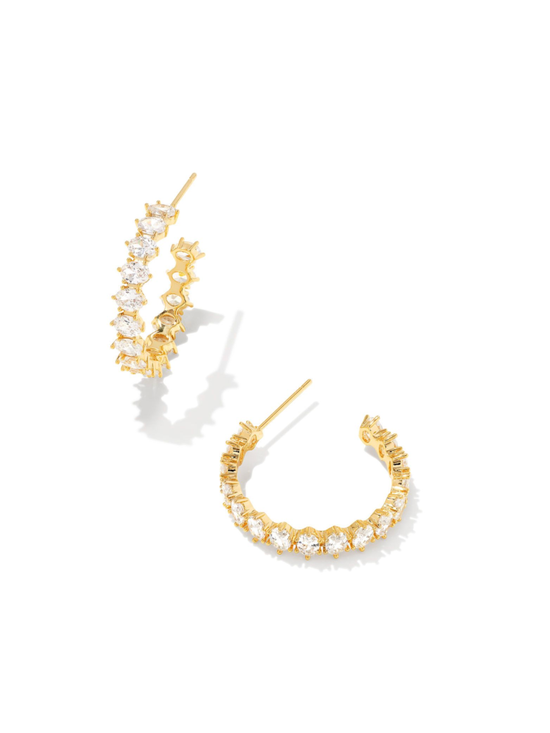 A pair of gold hoop earrings adorned with clear cubic zirconia stones, displayed on a clean white background with soft shadows.