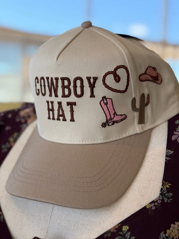 A cream-colored baseball cap with a tan visor, featuring embroidered brown text reading &