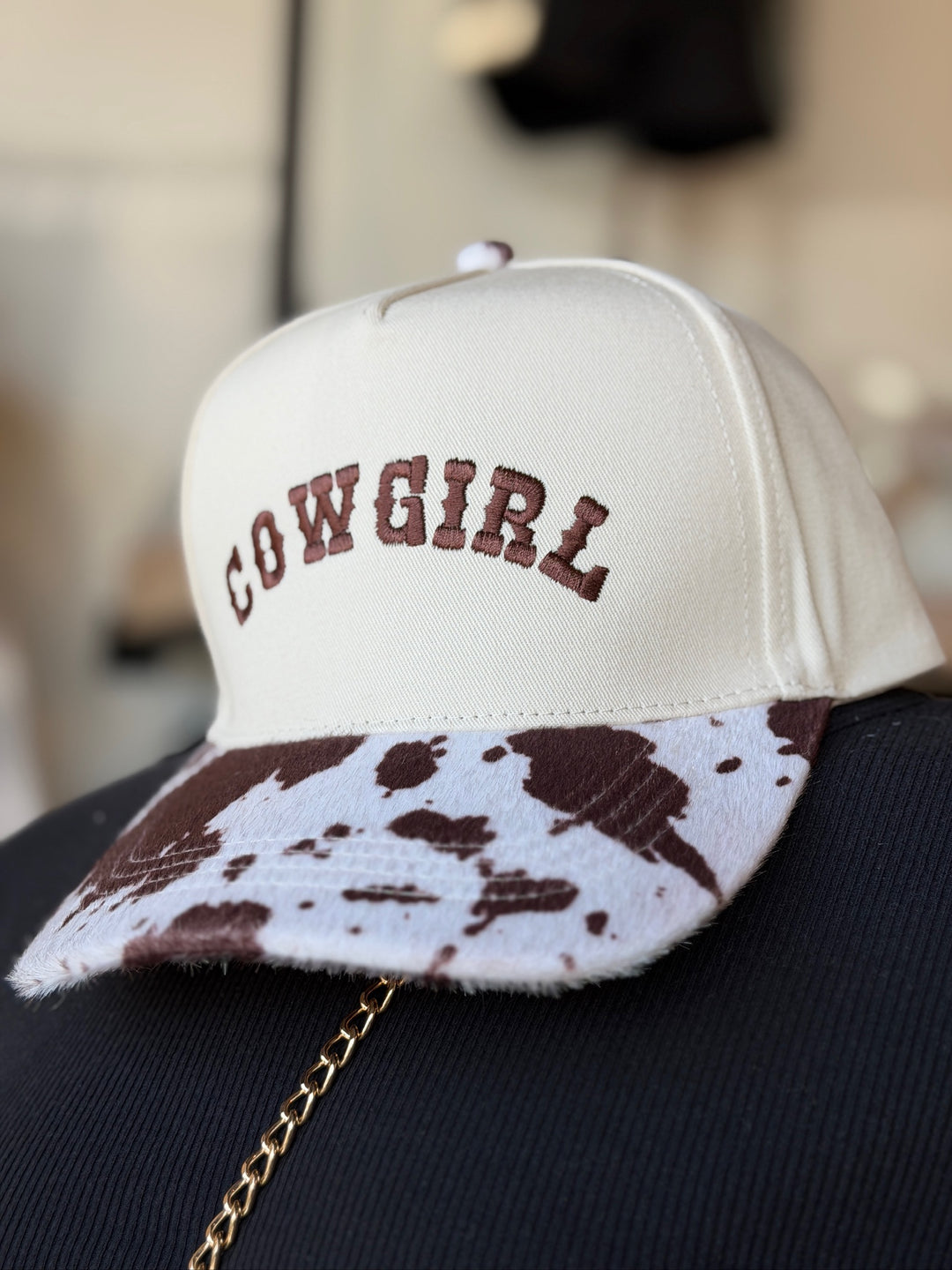 A cream-colored snapback cap with &