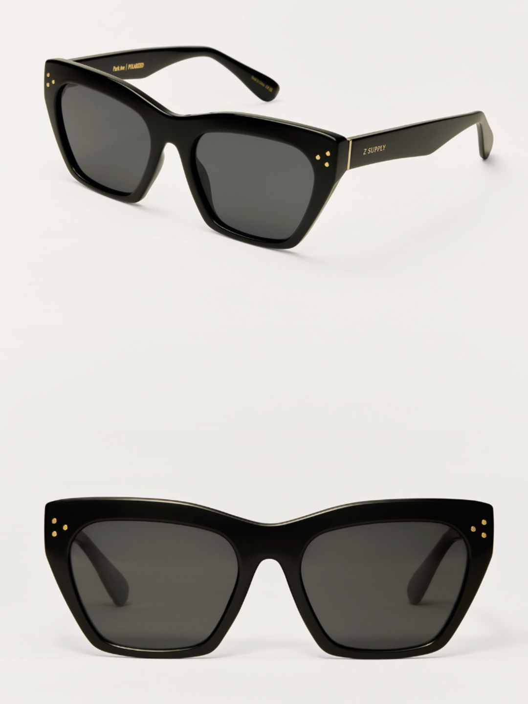 Two views of black cat-eye sunglasses with dark lenses and small gold dot accents on the temples, shown on a light gray background.