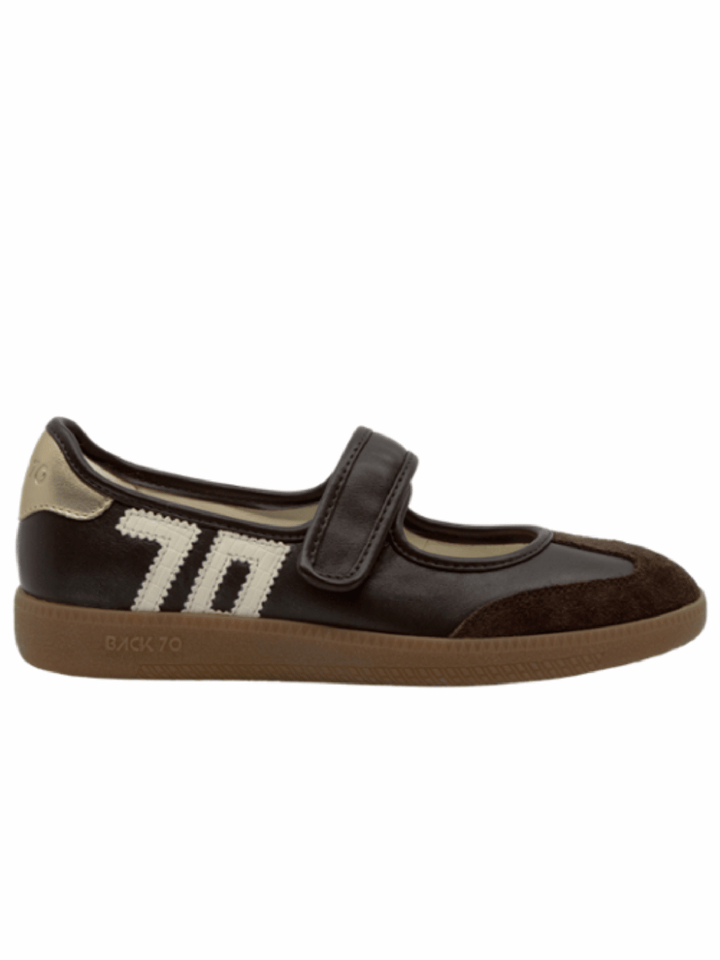 A dark brown leather and suede Mary Jane shoe with a hook-and-loop strap, a cream-colored woven &