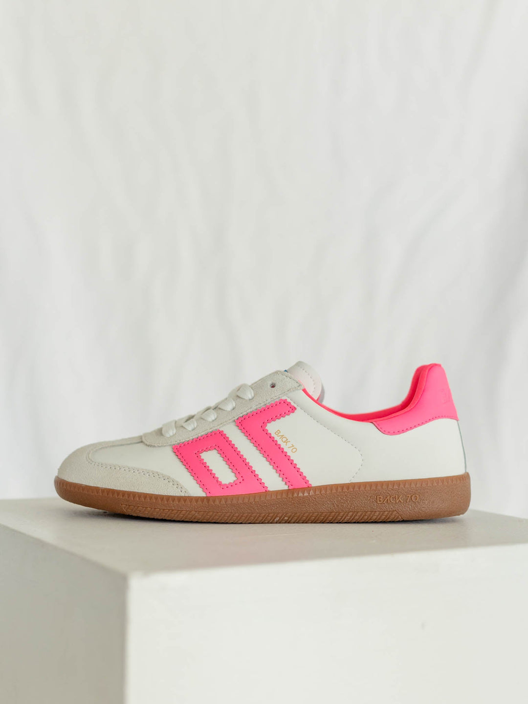 White sneaker with pink accents on a white background