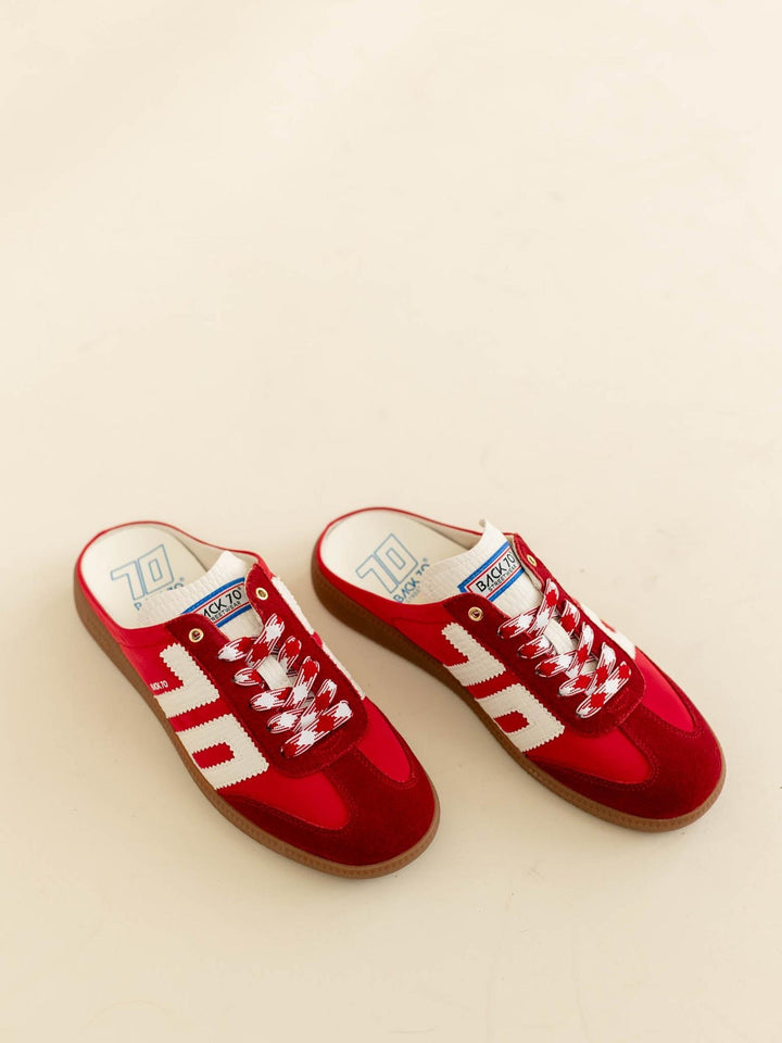 Red sneakers with white laces on a beige background