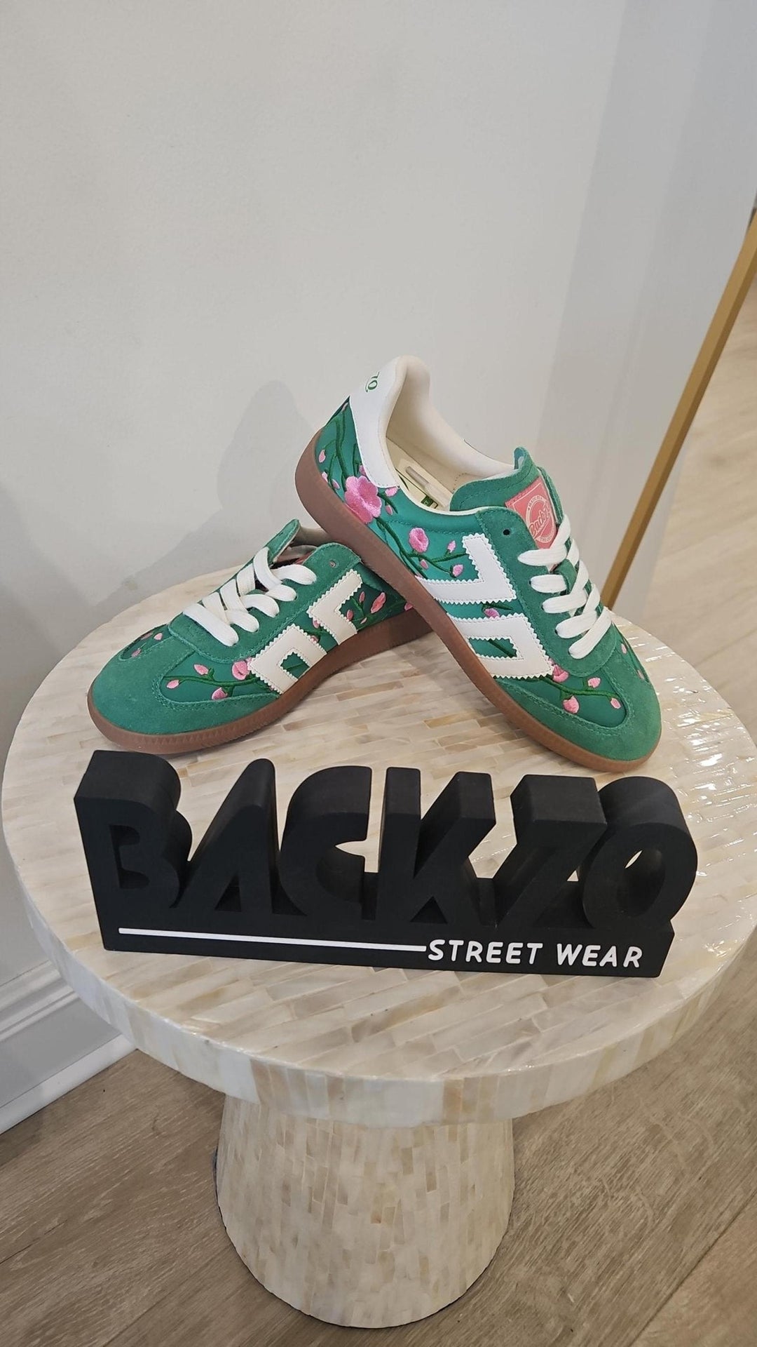Green sneakers with white accents on a wooden table with &