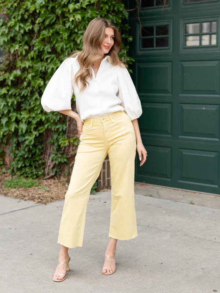 Woman wearing a white Balloon Sleeve Denim Shirt with yellow wide-leg pants, standing outdoors.