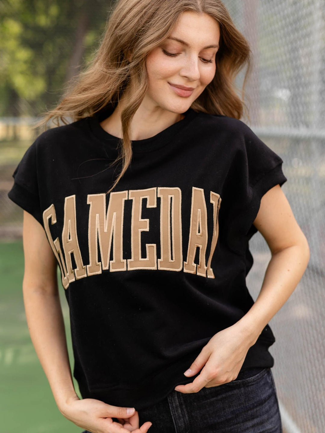 A woman wearing a black short-sleeve t-shirt with &