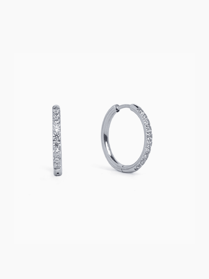 Pair of silver hoop earrings with embedded stones on a white background