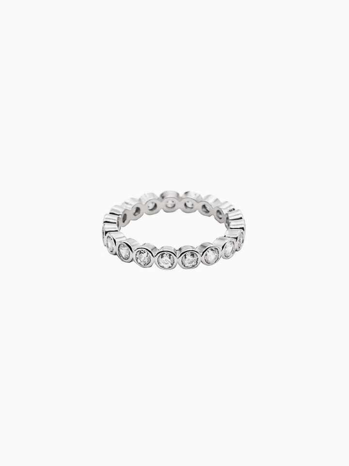 Silver ring with embedded crystals on a white background