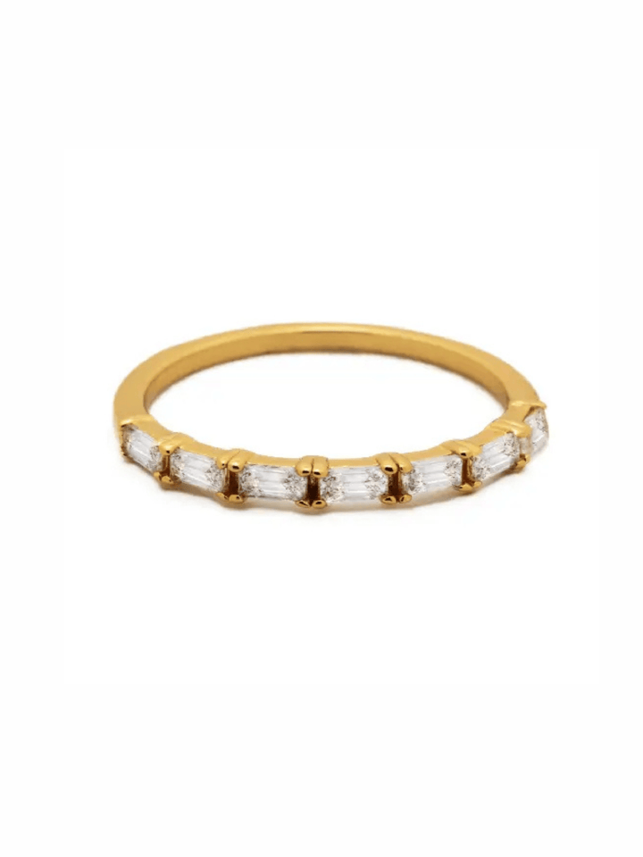 A yellow gold eternity ring featuring a row of baguette-cut clear gemstones in a prong setting, shown against a plain white background.