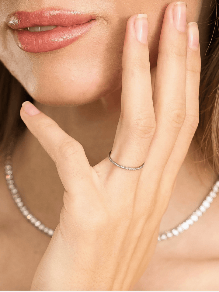 Close-up of a hand wearing a silver ring with a blurred background
