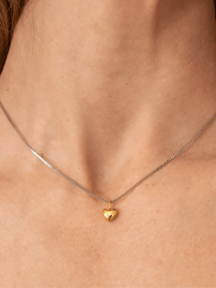 Gold heart pendant necklace on a person&