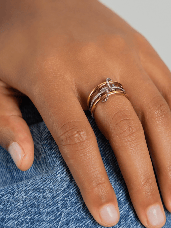 Close-up of a hand wearing a gold ring on a denim background