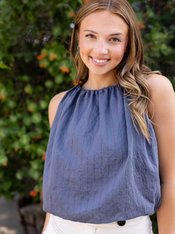 Model wears a Navy bubble striped tank top with a flowy silhouette and delicate thin stripes.