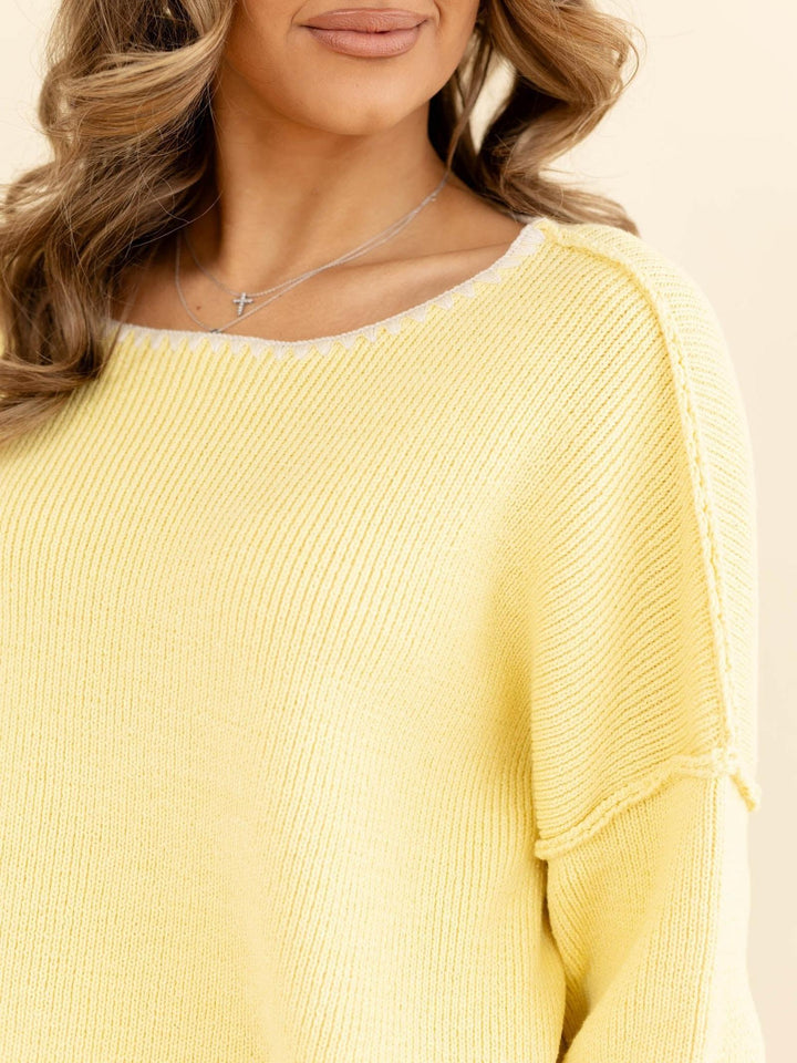 Yellow ribbed sweater worn by a person with a neutral background