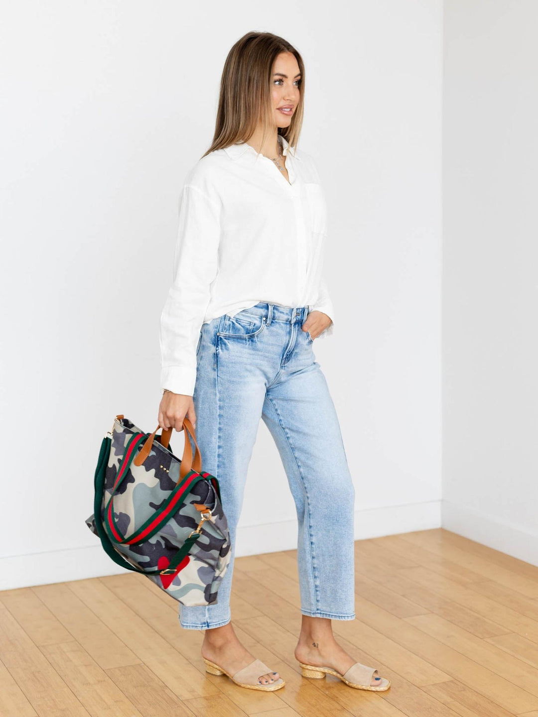 Woman holding a patterned bag in a minimal indoor setting
