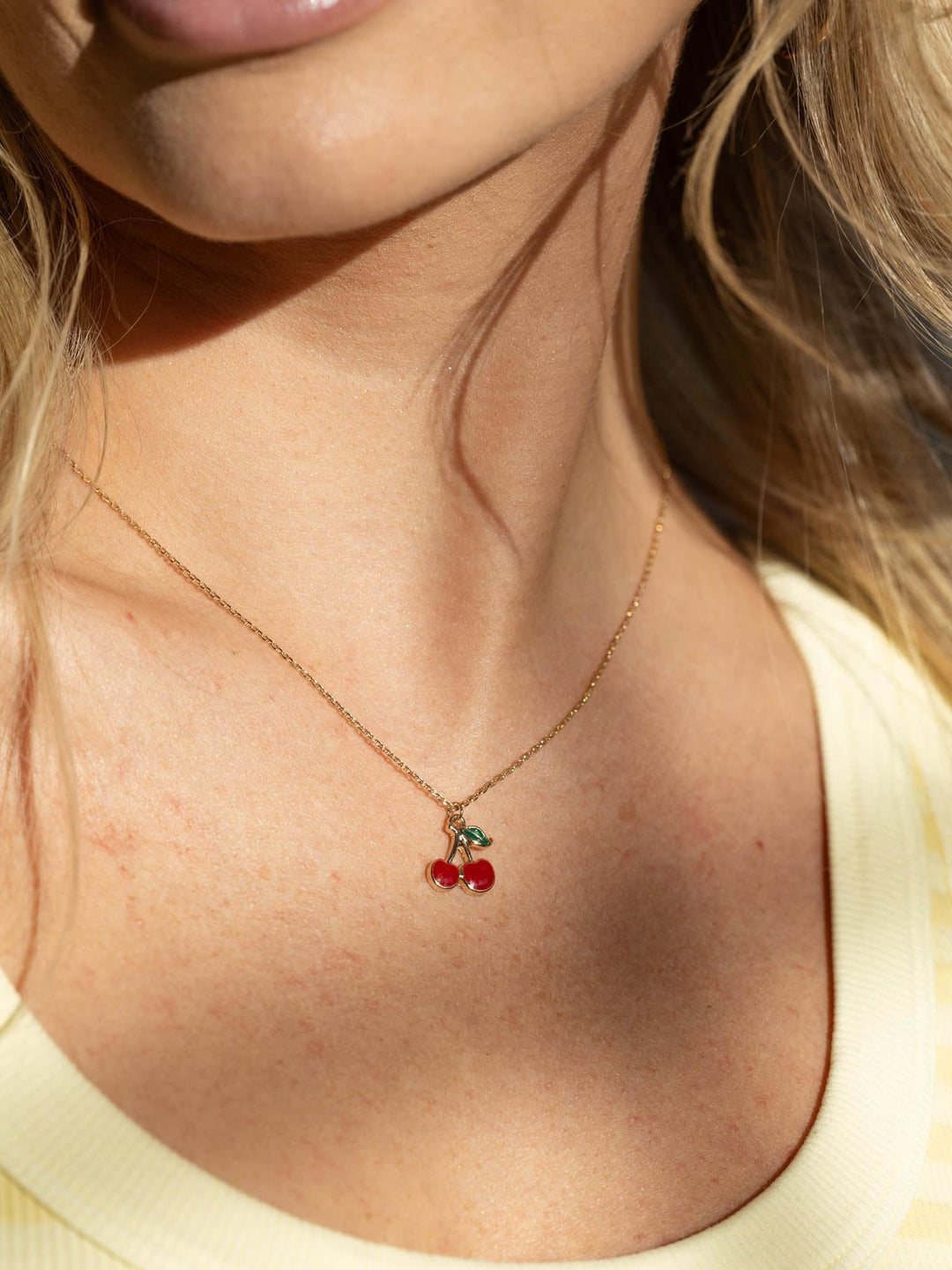 Necklace with cherry pendant worn by a person