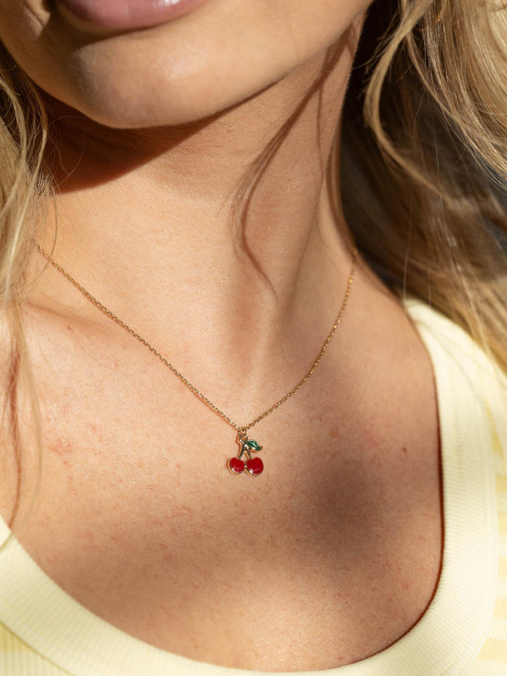 Necklace with cherry pendant worn by a person