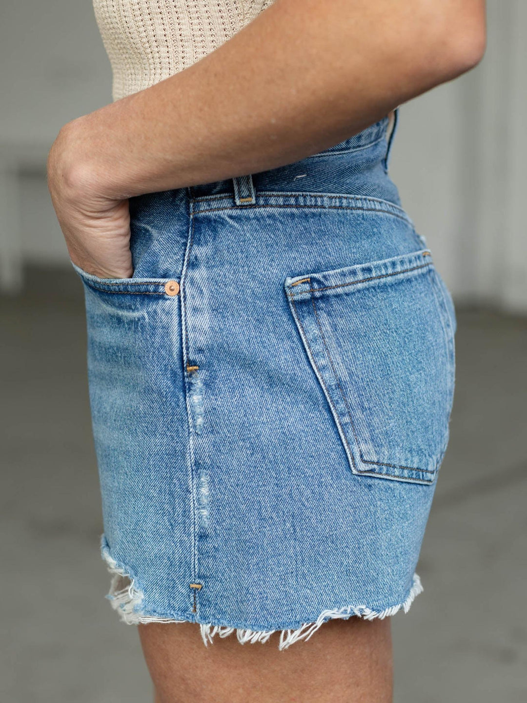 Denim skirt worn by a person with a neutral background