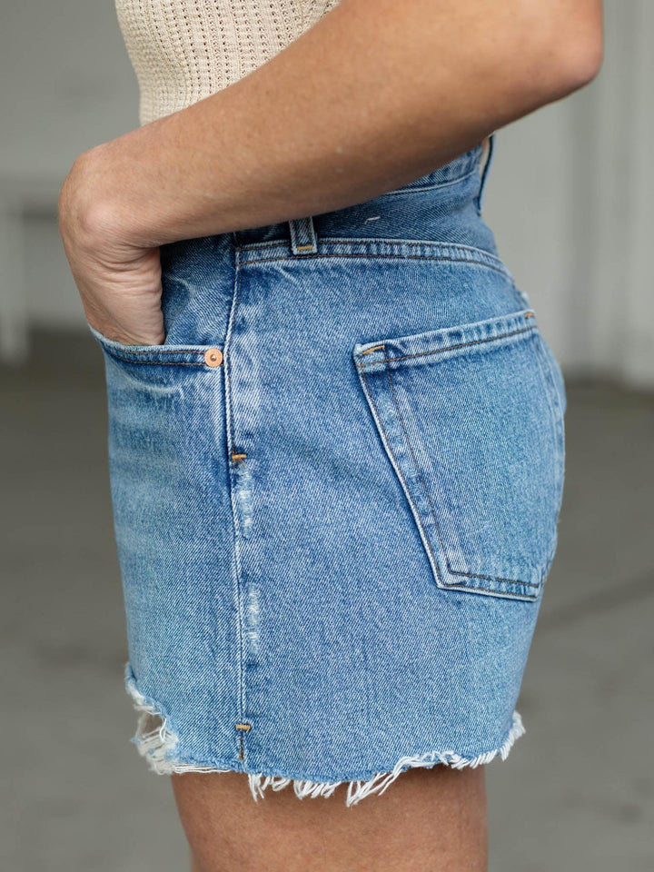 Denim skirt worn by a person with a neutral background