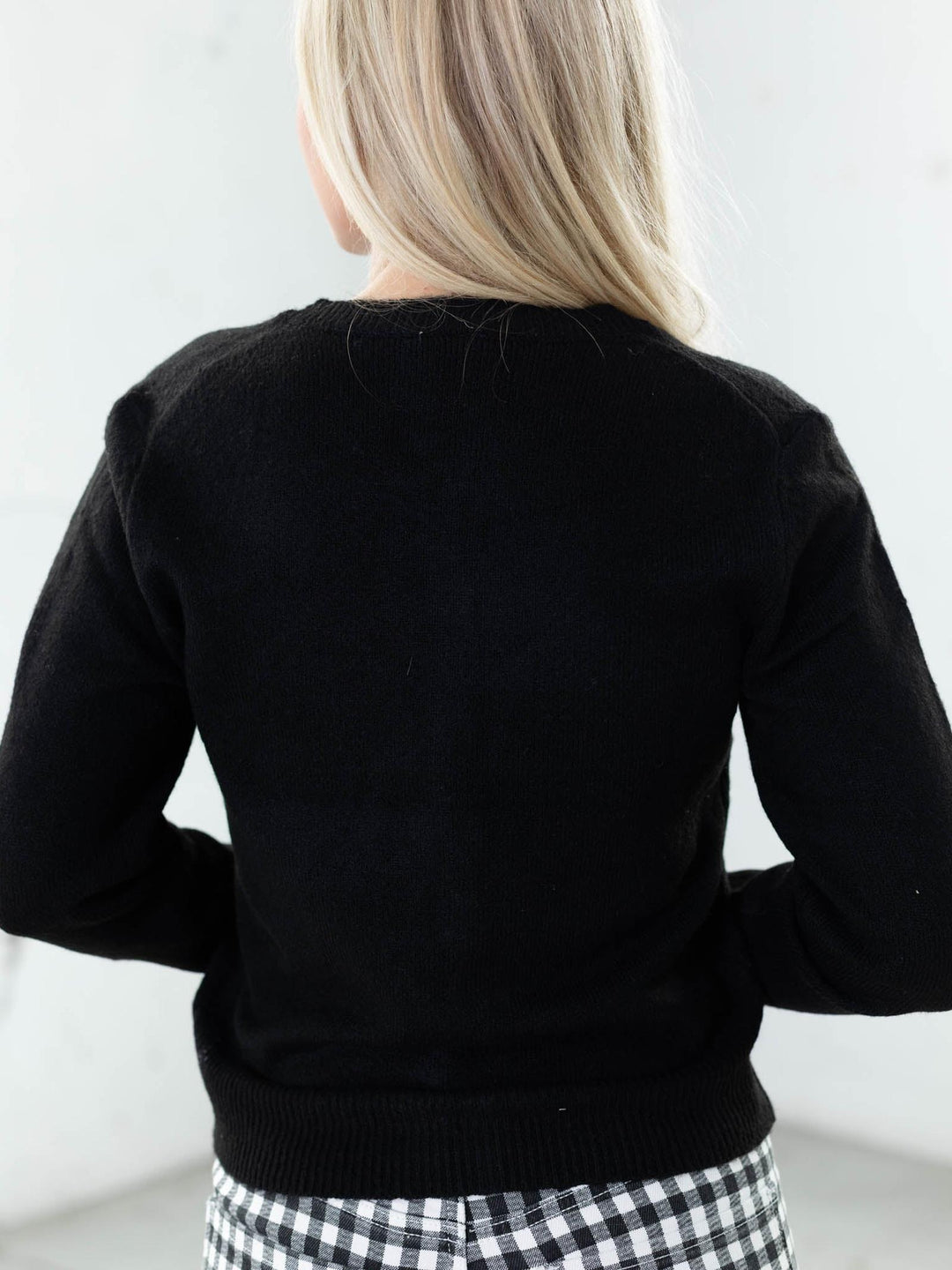 Person wearing a black sweater with a white background