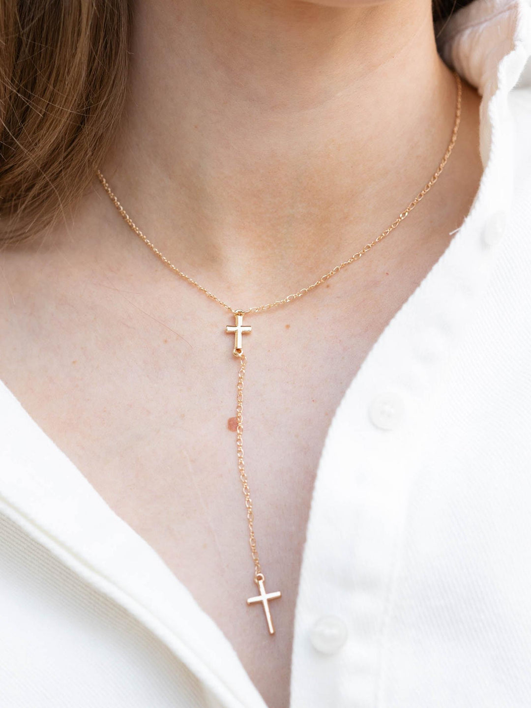 Gold Cross Y Drop Necklace on a woman&