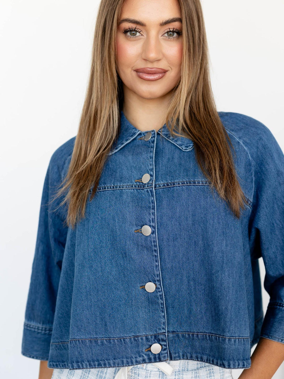 Woman wearing a blue denim jacket on a white background