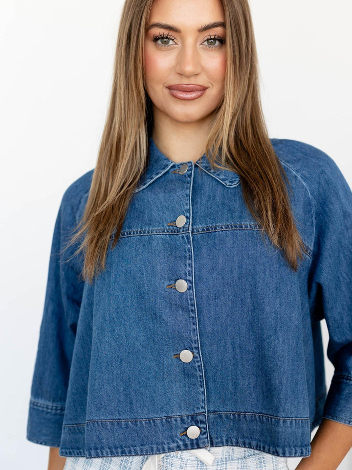 Woman wearing a blue denim jacket on a white background