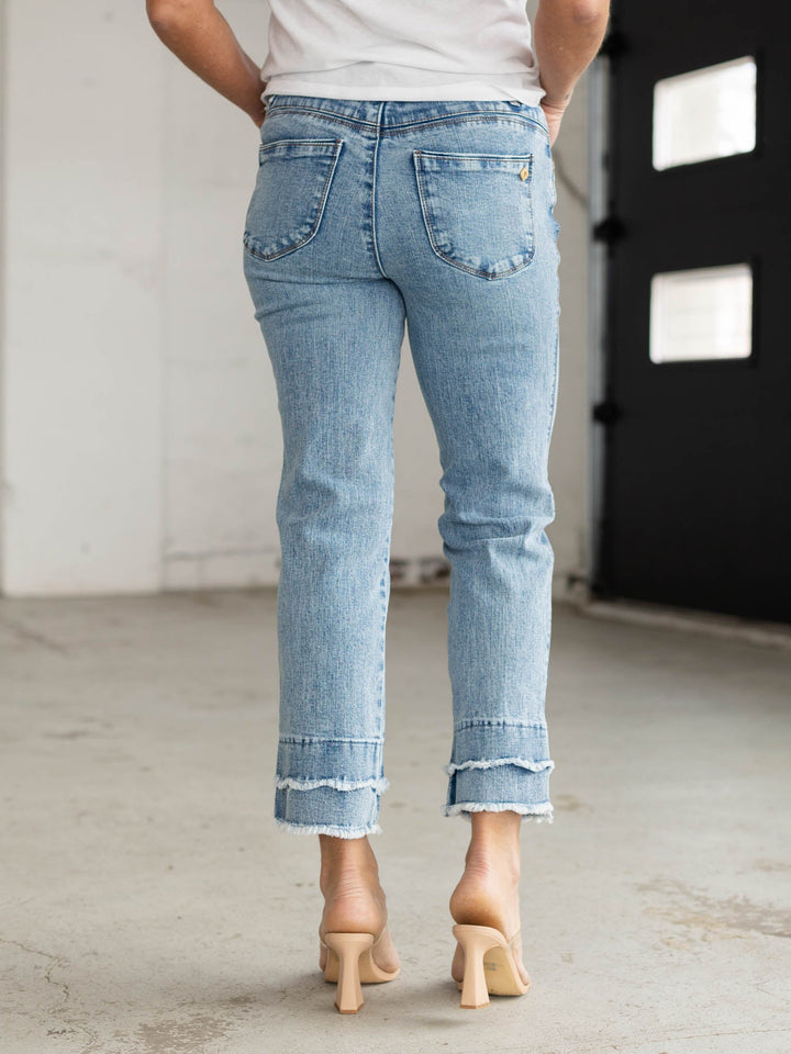 Person wearing light blue jeans with a blurred background