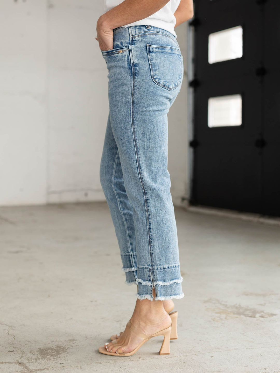 Person wearing light blue jeans with a blurred background