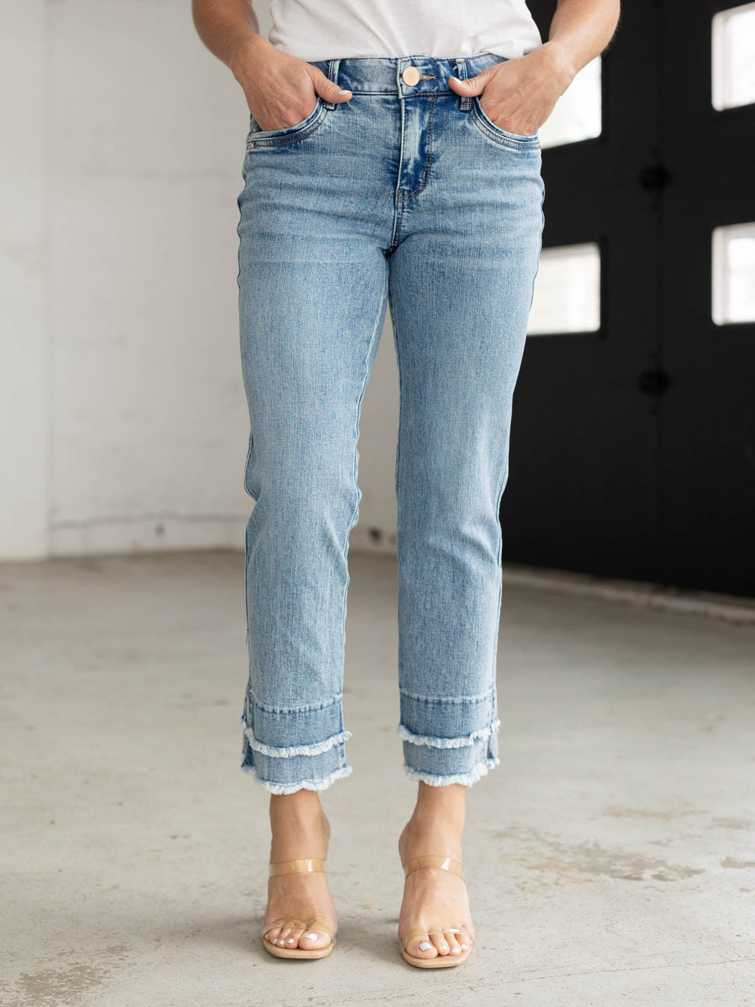 Person wearing light blue jeans with a blurred background