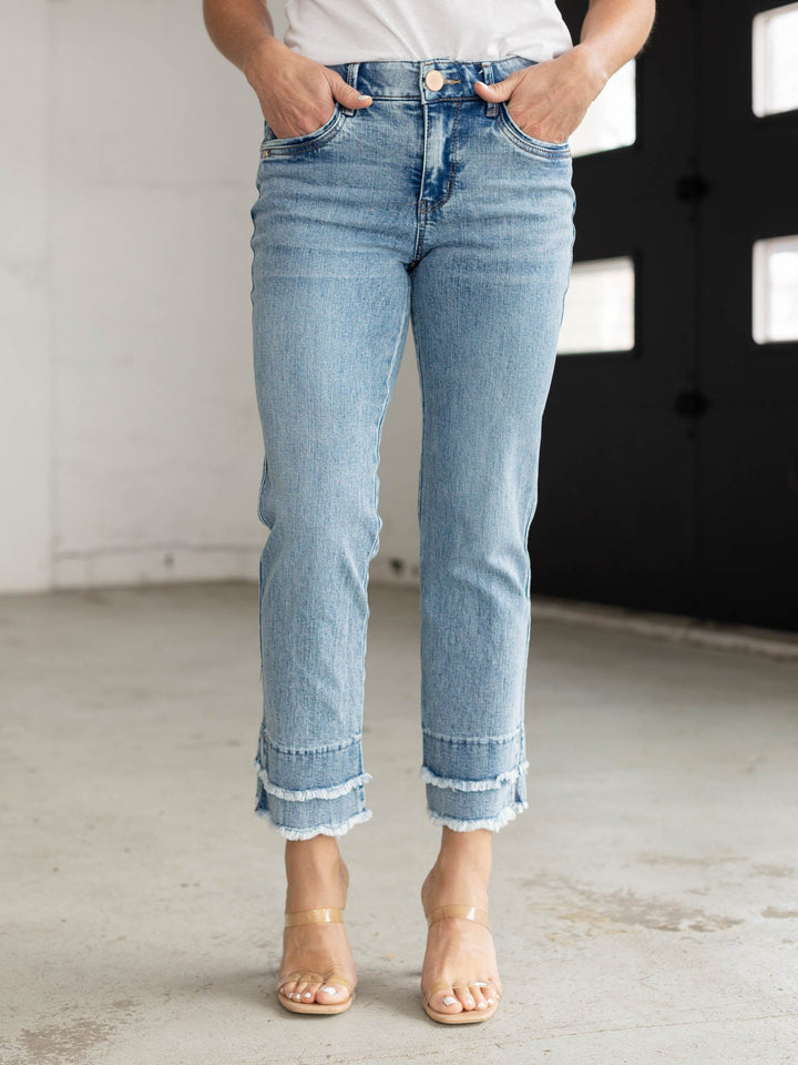 Person wearing light blue jeans with a blurred background