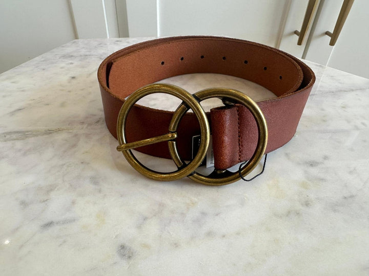 Brown belt with gold buckle on a marble surface