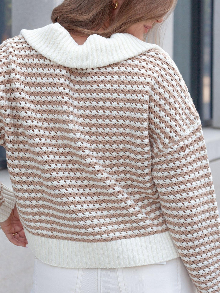 A close-up back view of a woman wearing a textured knit sweater with horizontal beige and white stripes, featuring a prominent white ribbed collar and hem.