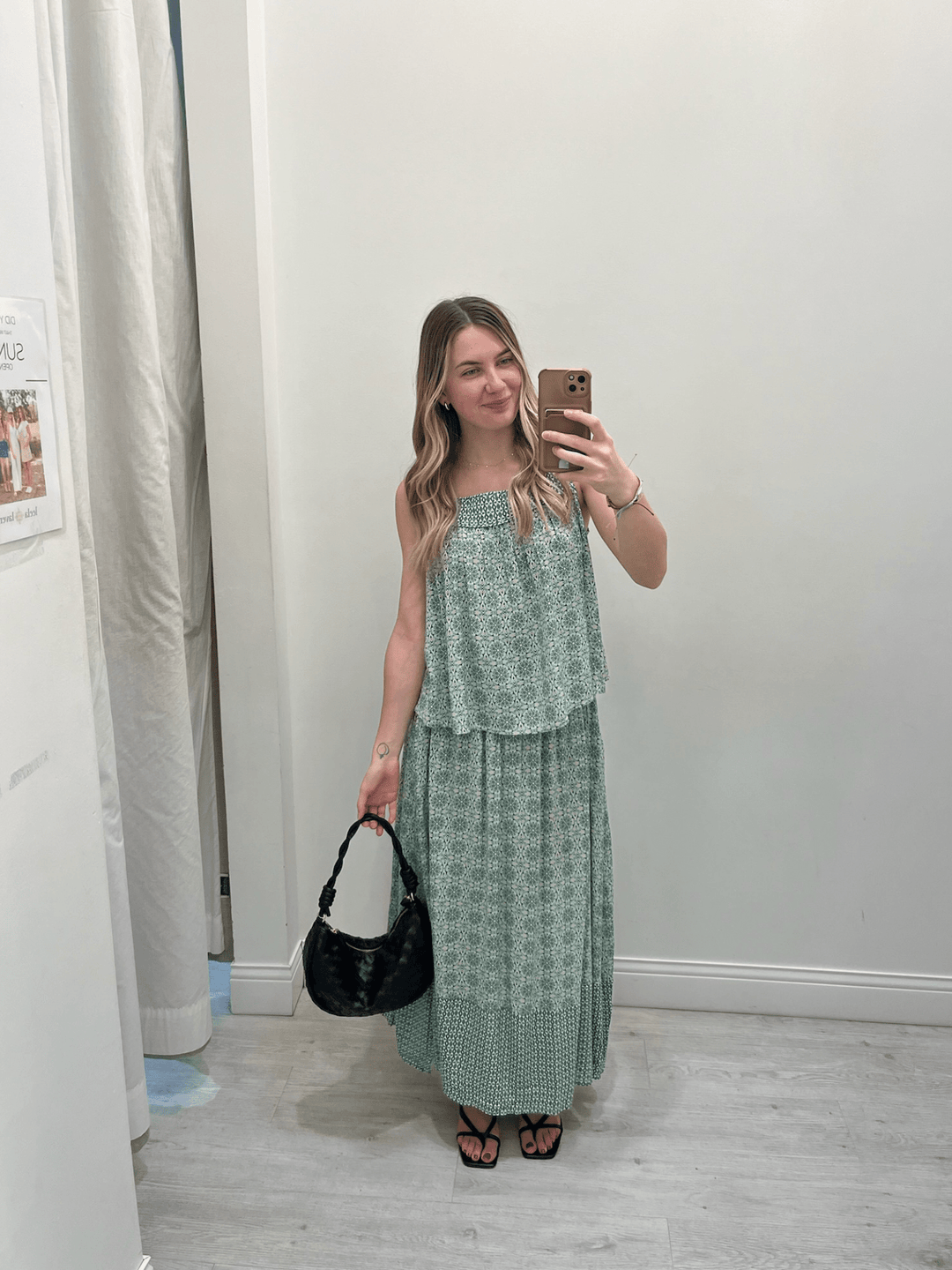 Woman taking a mirror selfie wearing a green patterned outfit.