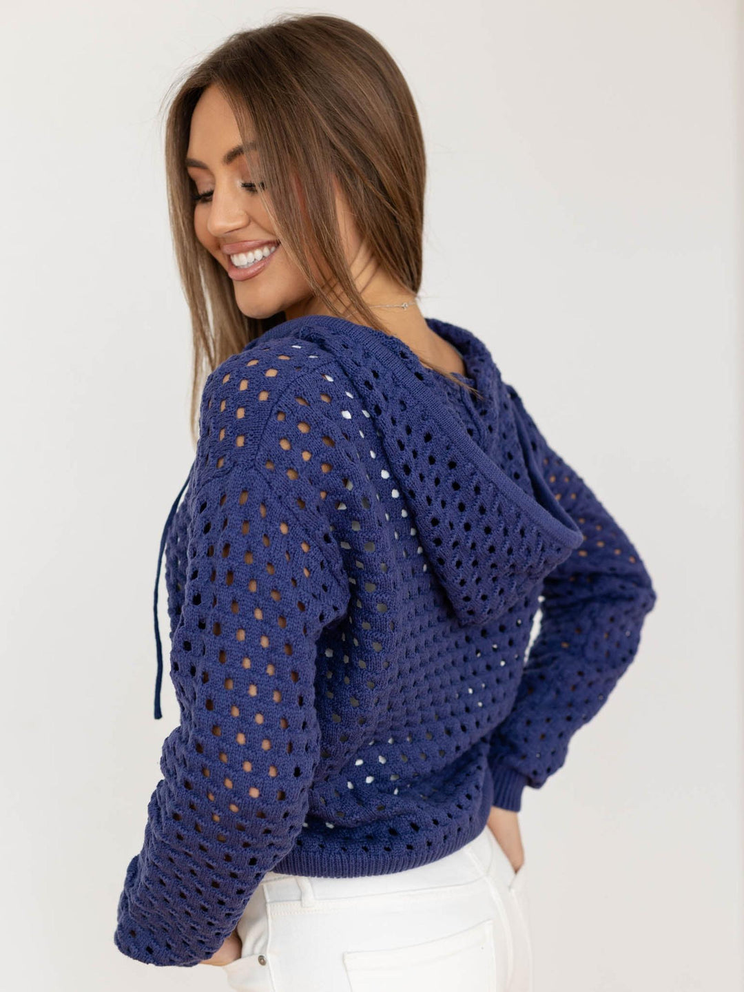 Woman wearing a blue crochet hoodie on a white background