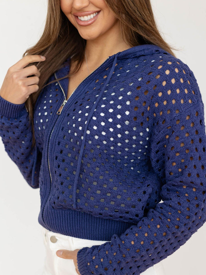 Woman wearing a blue open-knit cardigan on a white background