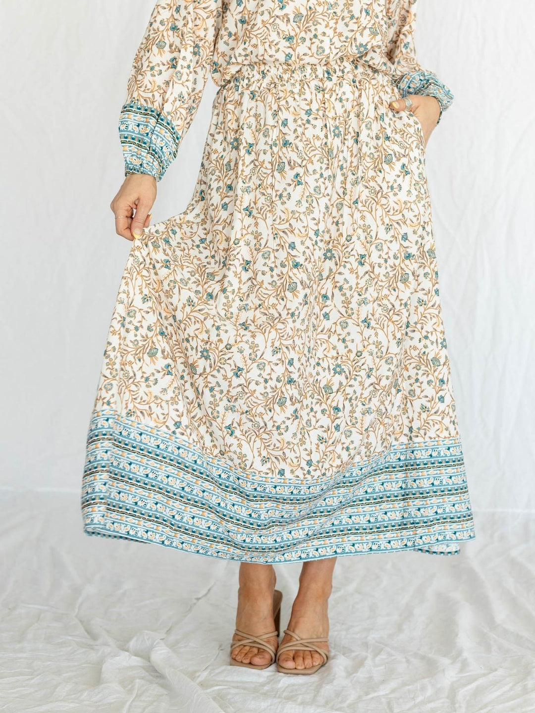 Long floral dress with a patterned hem on a white background