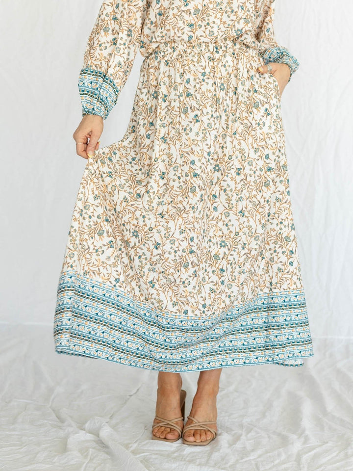 Long floral dress with a patterned hem on a white background