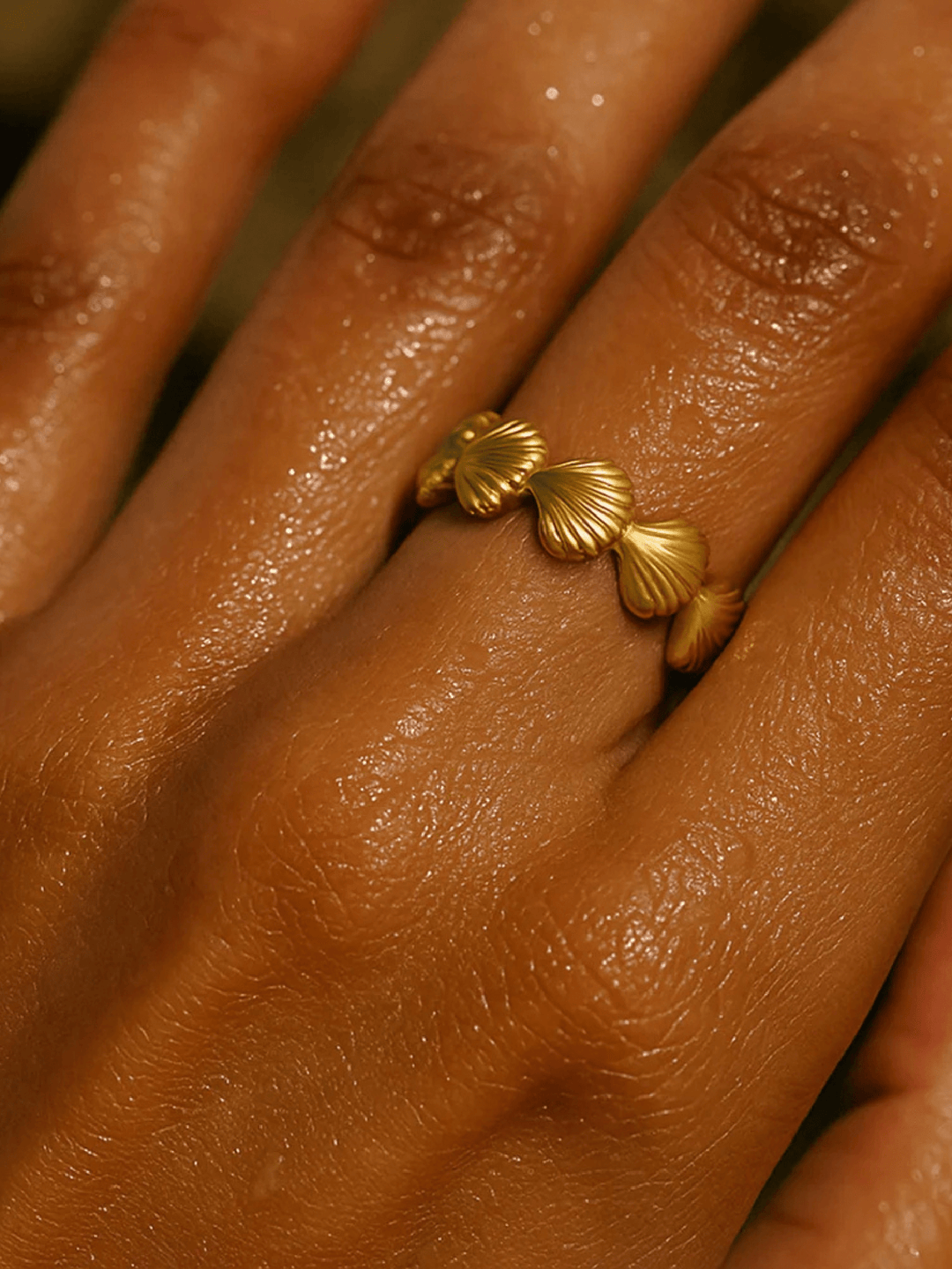 Gold ring with shell design on a person&