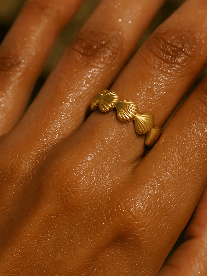 Gold ring with shell design on a person&