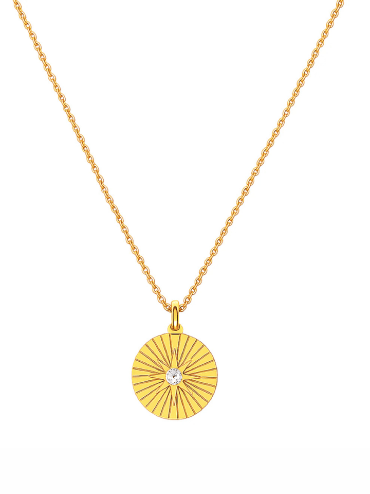 Gold necklace with a circular pendant on a white background
