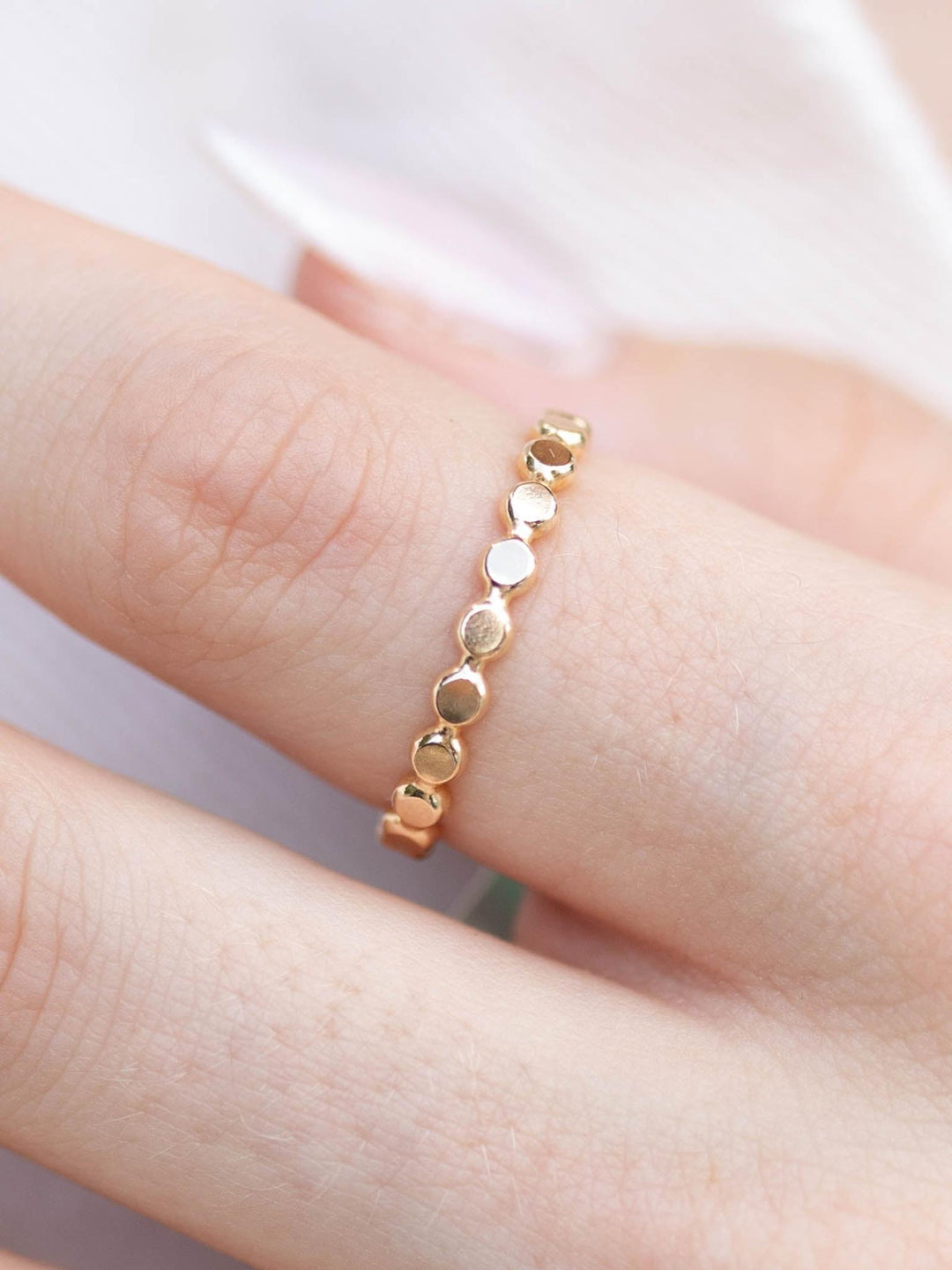 enewton Classic Gold 2.5mm Beaded Disc Ring on a finger, featuring delicate warm gold discs.