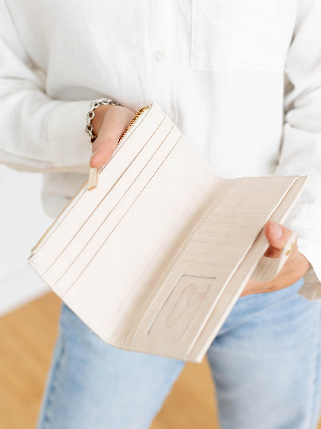 Person holding a beige wallet with a blurred background