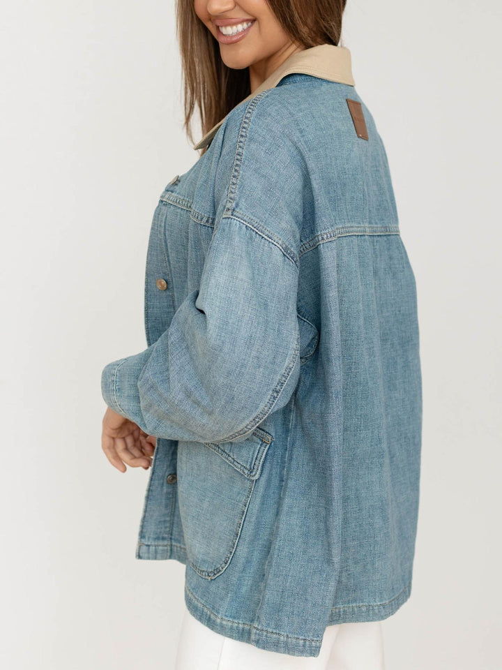 Denim jacket worn by a person on a white background