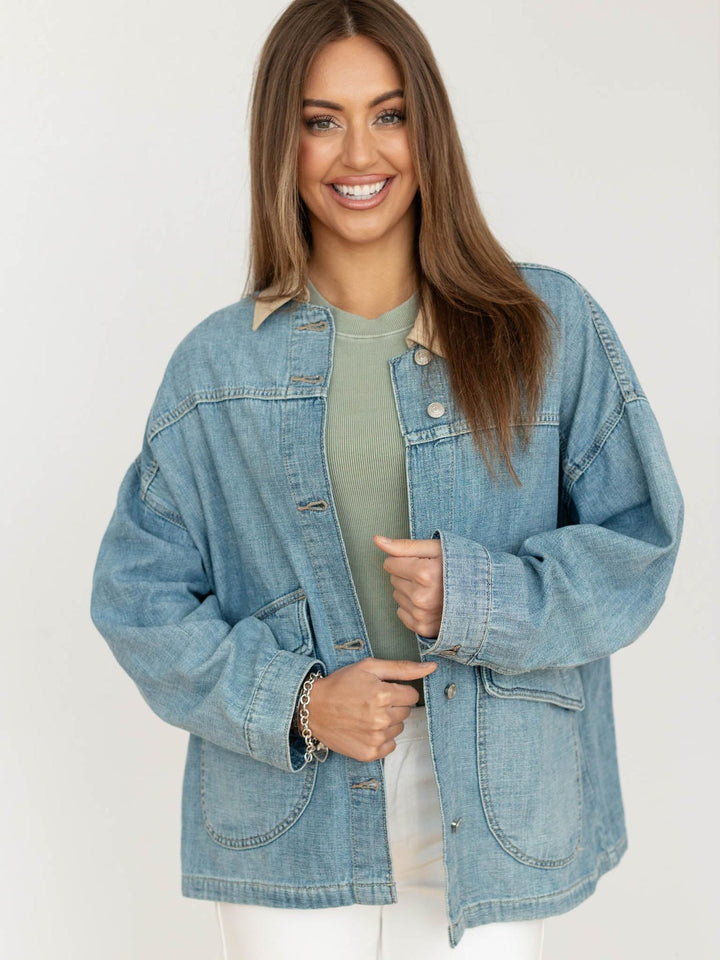 Woman wearing a denim jacket on a plain background