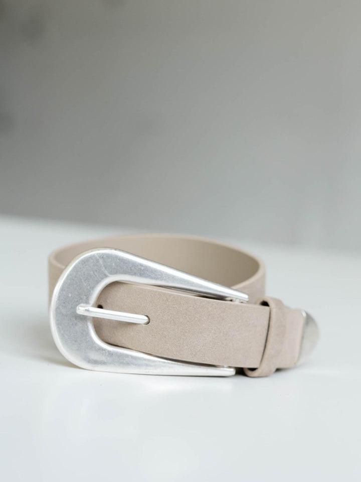 Free People Cannon Suede Belt in light tan with a large, rounded silver metal buckle.