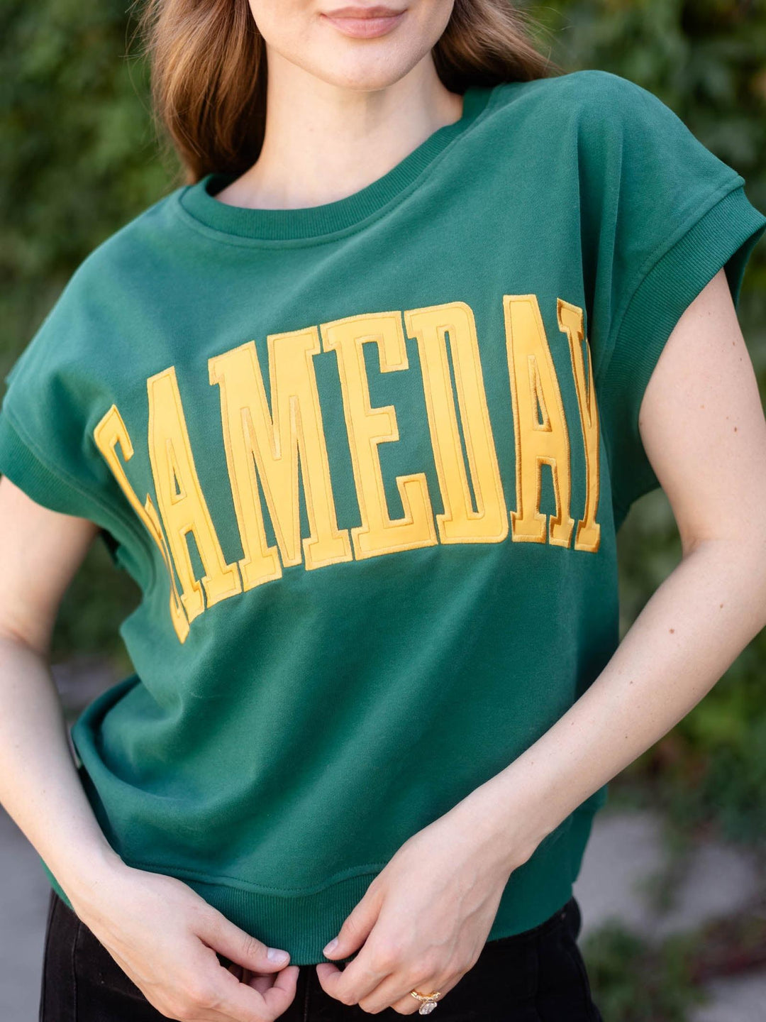 A woman wearing a green short-sleeve crewneck sweatshirt with &