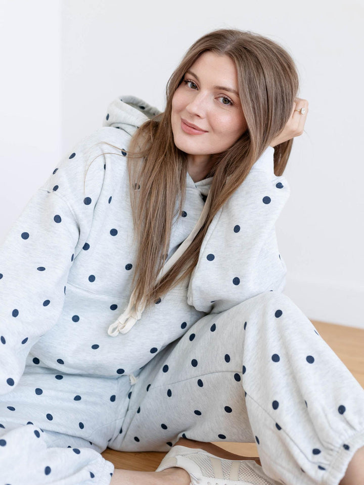 Woman wearing a polka dot robe sitting on a chair.